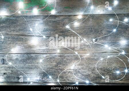 Burning lights garland on a wooden background. Side view. Stock Photo