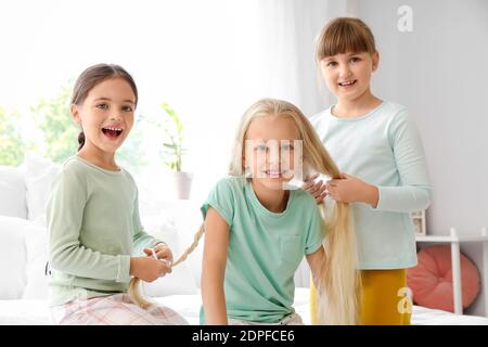 Cute hairdressers making braids in bedroom Stock Photo - Alamy