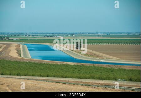 Water diversion canal to irrigate agricultural crops in California's Central Valley. Stock Photo