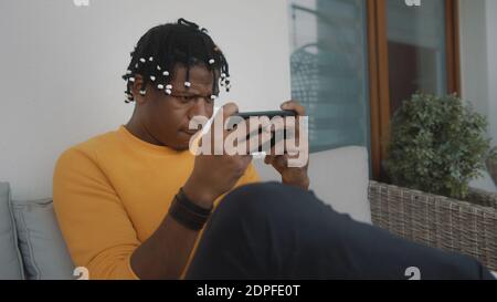 Portrait of focused african american black man playing games on the smartphone . High quality photo Stock Photo