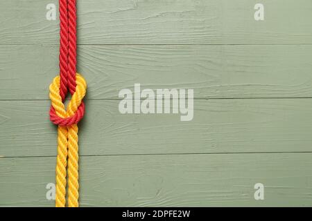 Rope with knot on wooden background Stock Photo