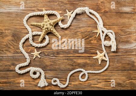 Frame made of rope and marine decor on wooden background Stock Photo
