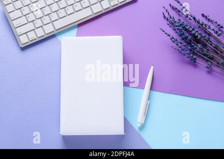 Composition with blank book and computer keyboard on color background Stock Photo