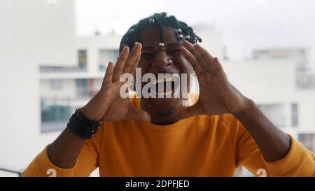 Excited african american man shouting WOW using his hands to amplify his voice. High quality photo Stock Photo
