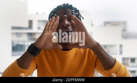 African american black man shouting WOW using his hands to amplify his voice. High quality photo Stock Photo