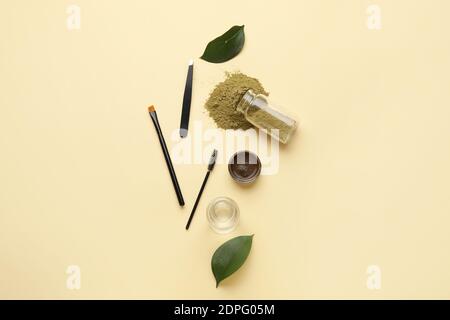 Composition with henna for eyebrows correction on color background Stock Photo