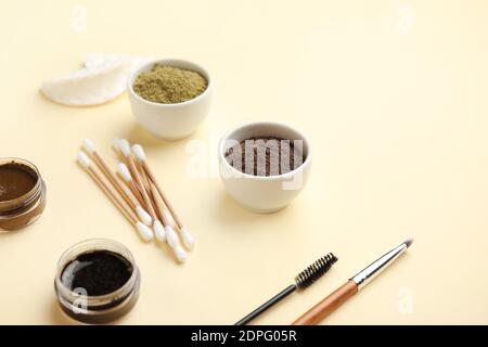 Composition with henna for eyebrows correction on color background Stock Photo