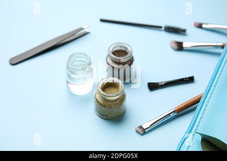 Composition with henna for eyebrows correction on color background Stock Photo