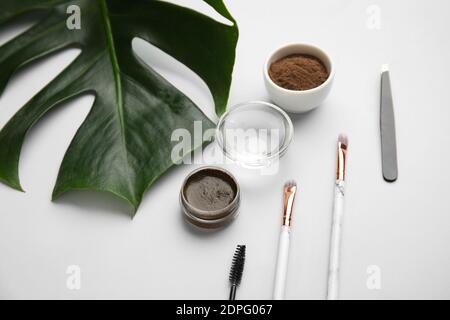 Composition with henna for eyebrows correction on light background Stock Photo