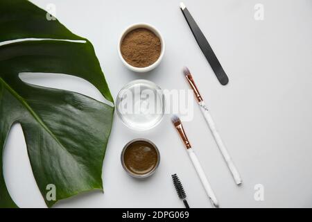 Composition with henna for eyebrows correction on light background Stock Photo