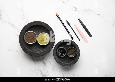 Composition with henna for eyebrows correction on light background Stock Photo