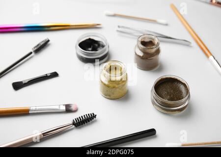Composition with henna for eyebrows correction on light background Stock Photo