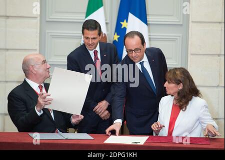 French President Francois Hollande (back, R) with his Mexican counterpart Enrique Pena Nieto (back, L) as French Minister of Ecology, Sustainable Development and Energy Segolene Royal (R) and her Mexican counterpart Juan Jose Guerra Abud sign a joint declaration on climate during an agreements signing ceremony at the Elysee Palace in Paris, France on July 16, 2015. More than 60 accords, letters of intent, joint declarations and memorandums of understanding have been signed between Mexico and France during President Pena Nieto's four-day state visit to France. Photo by Laurent Chamussy/Pool/ABA Stock Photo