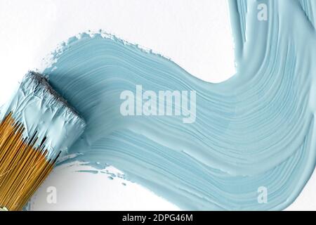 Blue paint and close up view of paint brush on white background Stock Photo