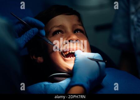 Dentist Operating Cheerful Boy In Medical Clinic