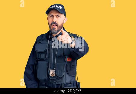 Young handsome man wearing police uniform pointing displeased and frustrated to the camera, angry and furious with you Stock Photo