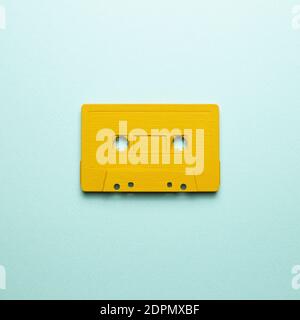 Yellow audio cassette tape on blue background. top view, copy space Stock Photo