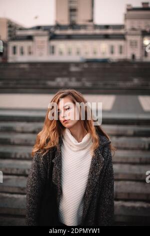 Portrait of sad teenage girl standing in city in autumn Stock Photo
