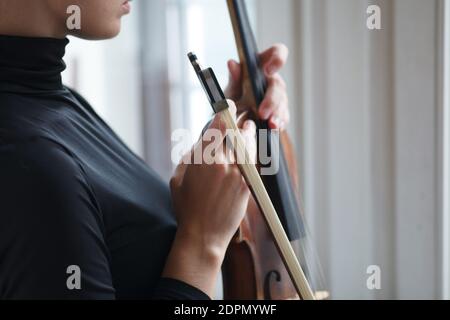 female hands holding alt violin with musician bow, close up detail Stock Photo