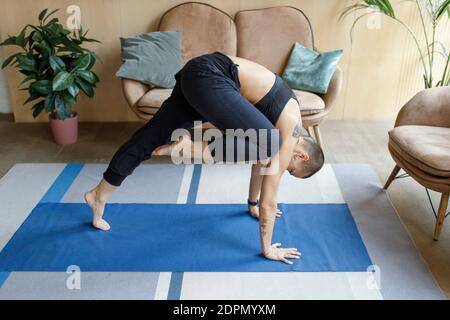 athletic female doing yoga lunge exercise in cozy home interior Stock Photo