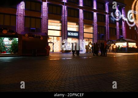 Buyers visit the Roshen candy store located on the territory of the chocolate factory of the same name. Factory decorated with Christmas illuminations Stock Photo