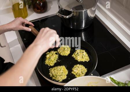 Young charming Swedish woman cooking at home in her kitchen, preparing healthy mediterranean food for her family. Young food blogger doing food prepar Stock Photo