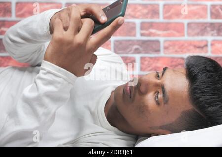 young man on bed using smart phone at night  Stock Photo