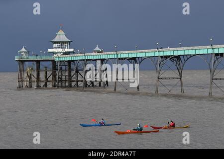 Clevedon, UK. 20th Dec, 2020. UK Weather.Clevedon, three canoeist seen paddling under world famous pier on a stormy afternoon begining to form with dramatic dark skyline. Picture Credit: Robert Timoney/Alamy Live News Stock Photo