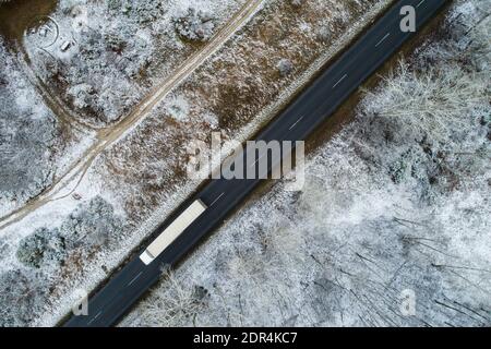 Truck on road with snowy forest in Hungary Stock Photo