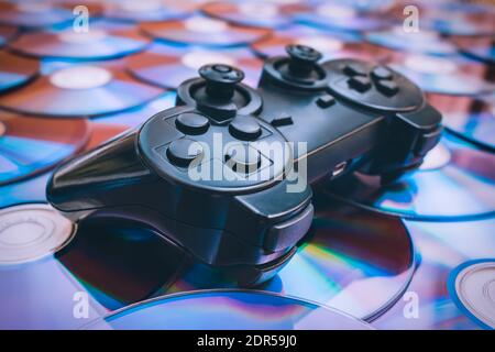 Video game joystick lying on discs close up Stock Photo
