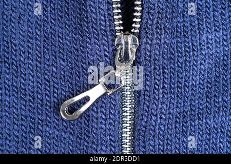 Macro shot of zipper on blue wool texture background with stitching. Horizontal background from a close-up of wool material Stock Photo