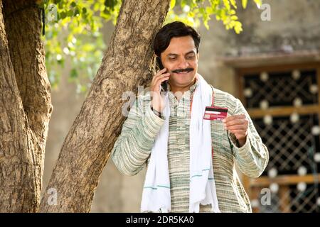 Famer using mobile phone and credit card for payment Stock Photo