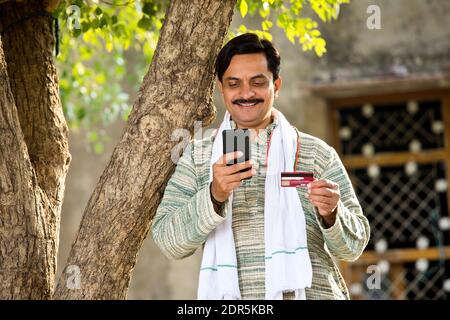 Famer using mobile phone and credit card for payment Stock Photo