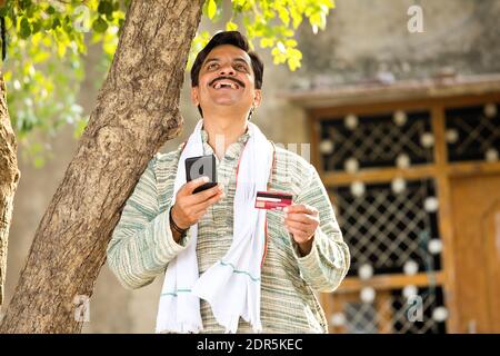 Famer using mobile phone and credit card for payment Stock Photo