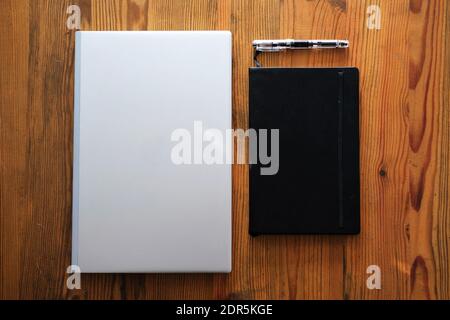 laptop, notebook and fountain pen on wooden table - remote learning concept photo Stock Photo