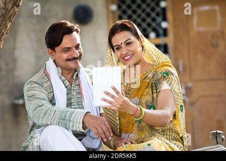 Rural Indian wife and husband using digital tablet at village Stock Photo