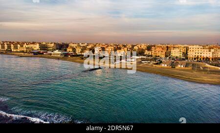 Sunset Rome aerial view in Ostia Lido beach over blue sea and brown sand beach, beautiful coast line and promenade a landmark of tourist and city life
