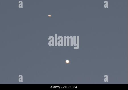 Wimbledon, London, UK. 20 December 2020. The ringed planet Saturn (upper left) and giant planet Jupiter, with 3 of its moons visible, appear after sunset above the rooftops in south west sky as they approach the great conjunction on the night of 21 December - the December solstice, though the view may be clouded out from London. The previous similar conjunction of the two planets in this distance visible from Earth was 800 years ago. Both planets are, nevertheless, approximately 400 million miles separation from one another. Credit: Malcolm Park/Alamy Live News.News. Stock Photo