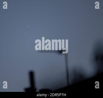 Wimbledon, London, UK. 20 December 2020. The ringed planet Saturn (upper left) and giant planet Jupiter, with 3 of its moons visible, appear after sunset above the rooftops in south west sky as they approach the great conjunction on the night of 21 December - the December solstice, though the view may be clouded out from London. The previous similar conjunction of the two planets in this distance visible from Earth was 800 years ago. Both planets are, nevertheless, approximately 400 million miles separation from one another. Credit: Malcolm Park/Alamy Live News.News. Stock Photo