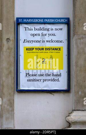 Sign on wall of St Marylebone Parish Church announcing building is open, with Covid-19 social distancing rules. Stock Photo