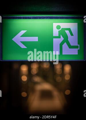 green emergency exit sign in hotel showing the way to escape Stock Photo