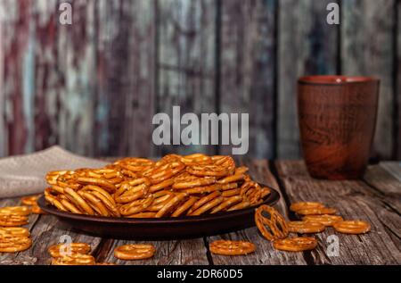 Mini pretzels with salt in a bowl on wooden background. Selective focus. Stock Photo
