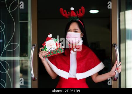 Woman in Santa Claus suit with wearing face mask  in christmas day Stock Photo