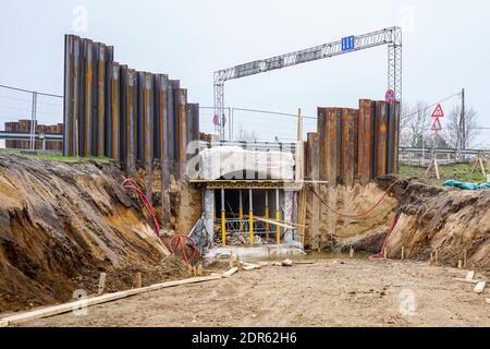 construction of a pedestrian tunnel under the highway, temporary metal retaining wall support the foundation Stock Photo