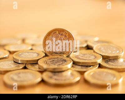 Close up of many GBP one pound coins on the table surface, UK Stock Photo