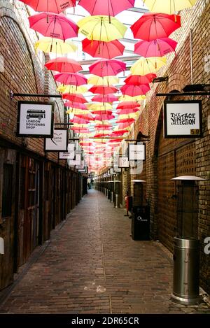 Camden Market alley with colourful umbrellas decorating the ceiling as they hang in the air as if by magic. Stock Photo