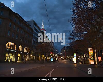 Night view of square Rotebühlplatz in downtown with retail and office buildings and illuminated advertising pillar. Stock Photo