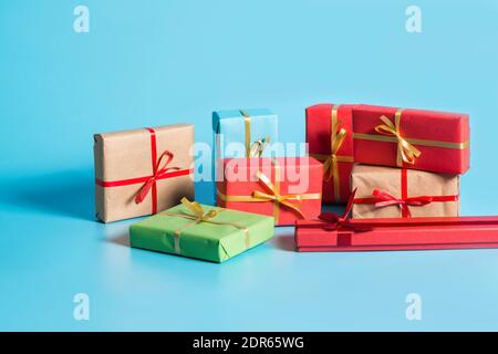 Boxes with gifts in colored paper with gold ribbons on a blue background. Copy Space Stock Photo