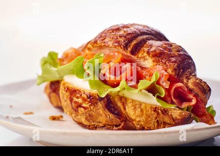 Yummy croissant with salmon and cream cheese on dish Stock Photo