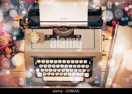 Vintage Christmas atmosphere with an old typewriter and pile of blank sheets to write letters and christmas greeetings. Stock Photo